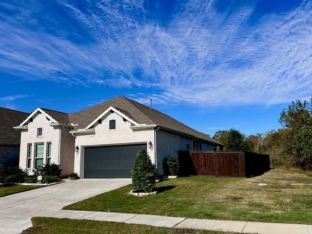 view of front of property featuring a garage and a front lawn