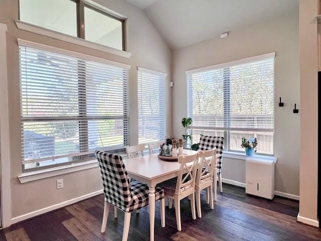 dining room featuring dark hardwood / wood-style flooring, vaulted ceiling, and a wealth of natural light