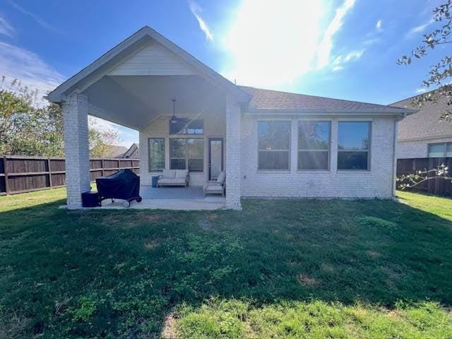 back of property featuring ceiling fan, a yard, and a patio