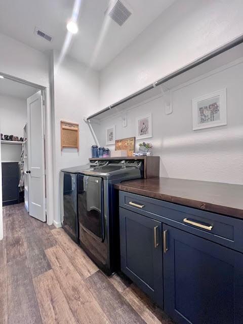 laundry room with cabinets, dark wood-type flooring, and washing machine and clothes dryer