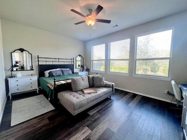 bedroom with dark hardwood / wood-style flooring and ceiling fan