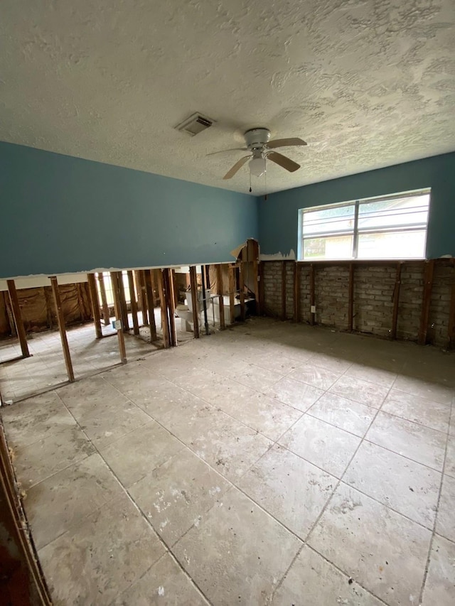 spare room with ceiling fan and a textured ceiling