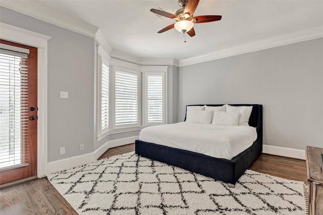 bedroom with ceiling fan, wood-type flooring, ornamental molding, and multiple windows