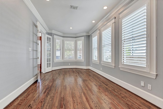 spare room featuring hardwood / wood-style floors and crown molding