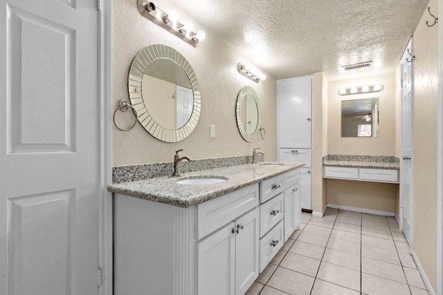 bathroom featuring tile patterned flooring, vanity, and a textured ceiling