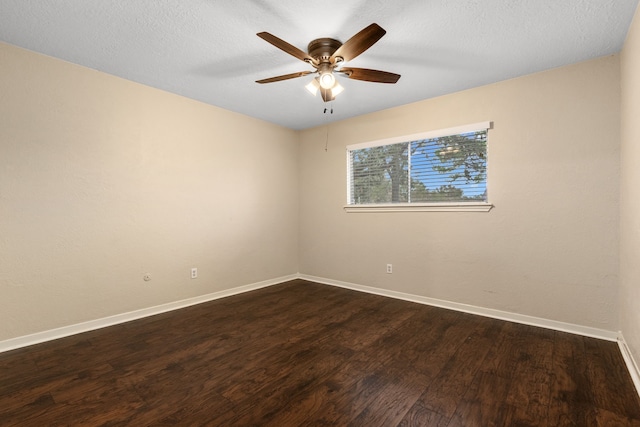 empty room featuring ceiling fan, dark wood-type flooring, and a textured ceiling