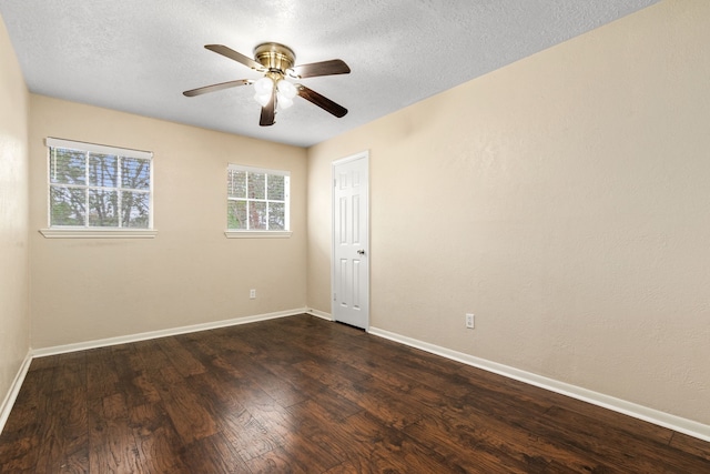 empty room featuring ceiling fan, dark wood-type flooring, and a textured ceiling