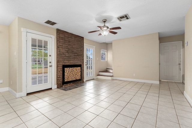 unfurnished living room featuring a fireplace, light tile patterned floors, and plenty of natural light