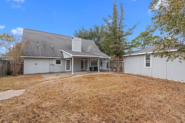 back of house with a yard and a patio