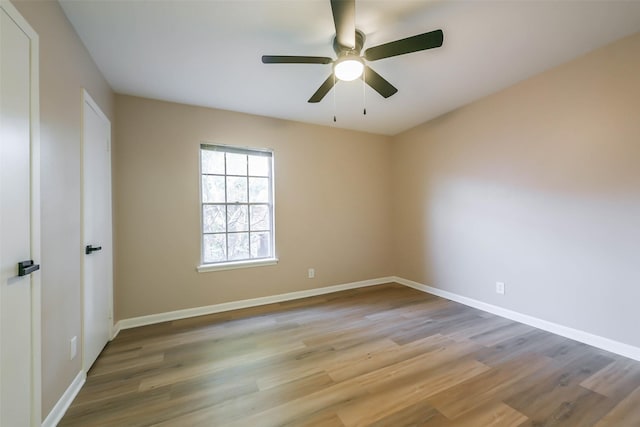 empty room with light wood-style floors, ceiling fan, and baseboards