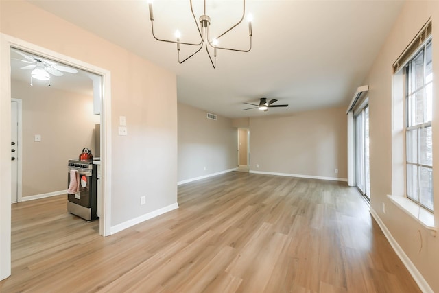 unfurnished room with light wood-type flooring, baseboards, and ceiling fan with notable chandelier