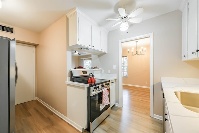 kitchen with light wood finished floors, appliances with stainless steel finishes, and white cabinetry