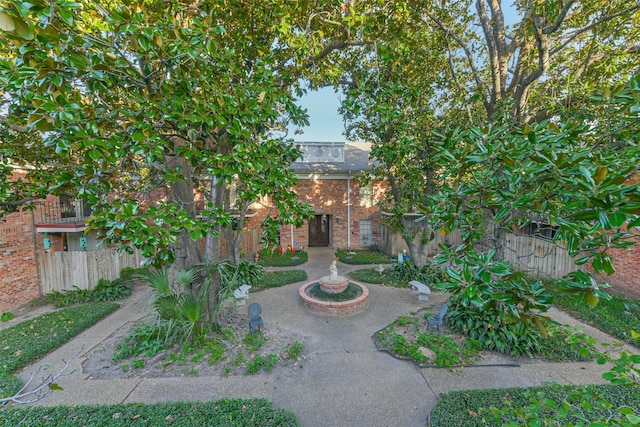 obstructed view of property featuring fence and brick siding