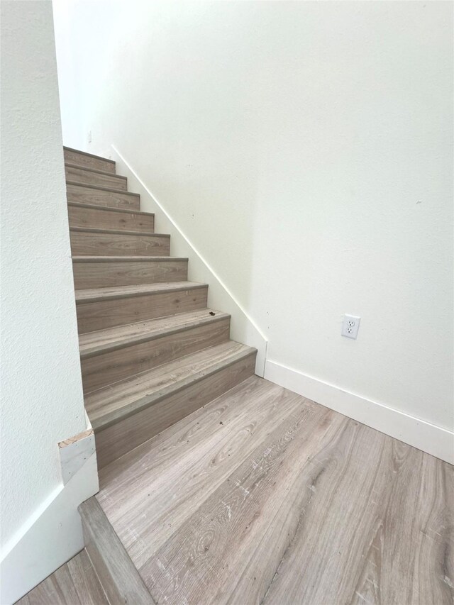 stairs featuring hardwood / wood-style floors