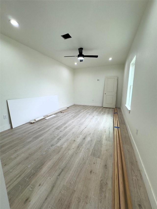 unfurnished room with ceiling fan and light wood-type flooring