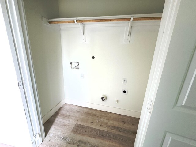 clothes washing area featuring hookup for a gas dryer, light hardwood / wood-style flooring, and electric dryer hookup