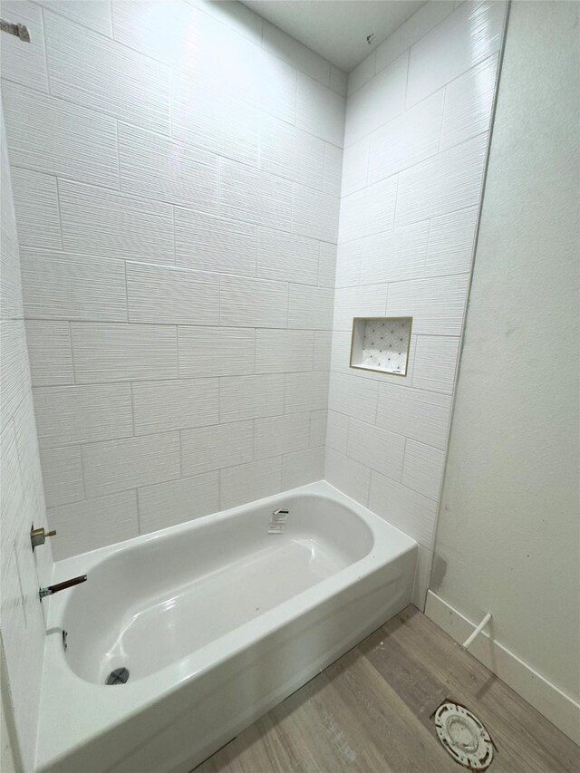 bathroom featuring hardwood / wood-style floors and tiled shower / bath combo