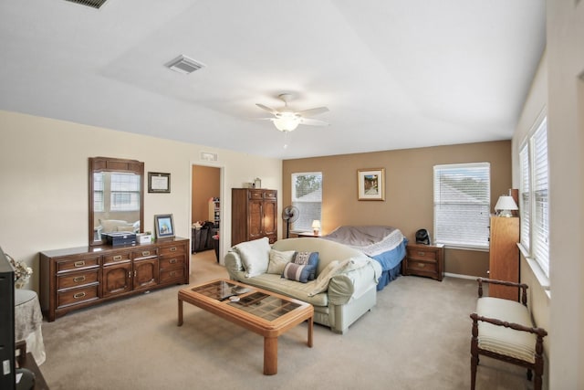 bedroom featuring a walk in closet, light carpet, ceiling fan, and a closet