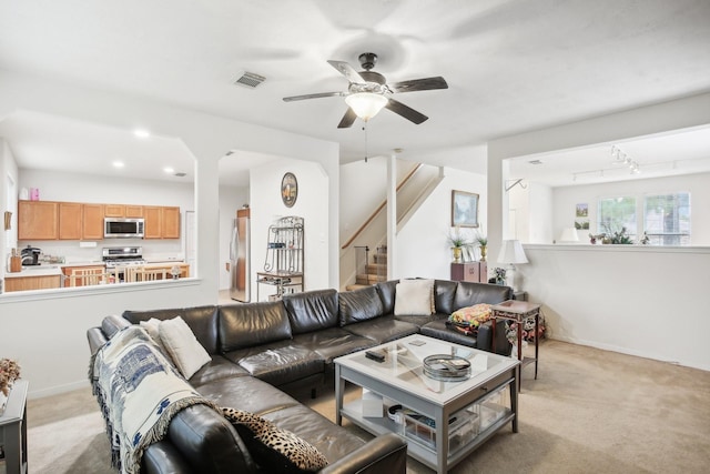 living room featuring light carpet, track lighting, and ceiling fan