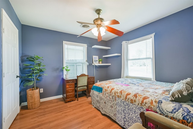 bedroom with visible vents, multiple windows, baseboards, and light wood-style flooring