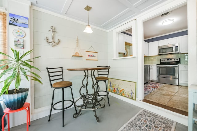 kitchen with visible vents, ornamental molding, decorative backsplash, appliances with stainless steel finishes, and white cabinetry