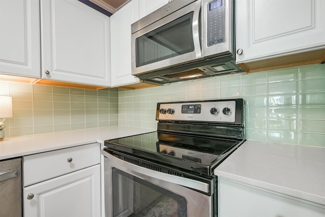 kitchen with backsplash, appliances with stainless steel finishes, and white cabinets