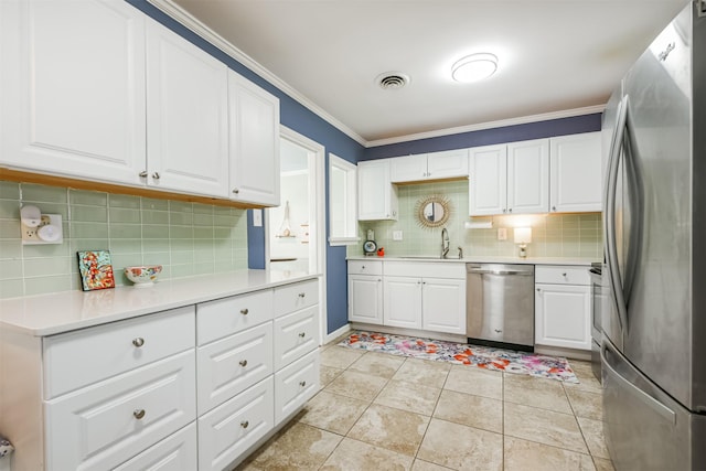 kitchen with light tile patterned floors, white cabinetry, appliances with stainless steel finishes, tasteful backsplash, and sink