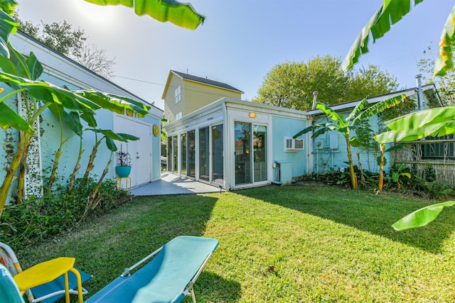 rear view of property with a yard and a sunroom