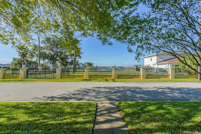 exterior space with a gate, a lawn, and a fenced front yard