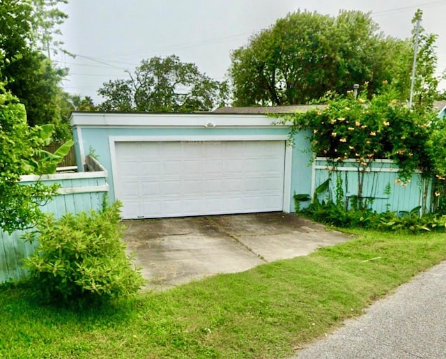 detached garage featuring fence