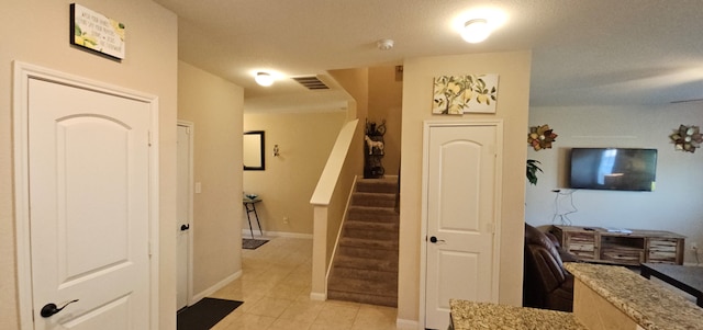 entryway featuring light tile patterned floors and a textured ceiling