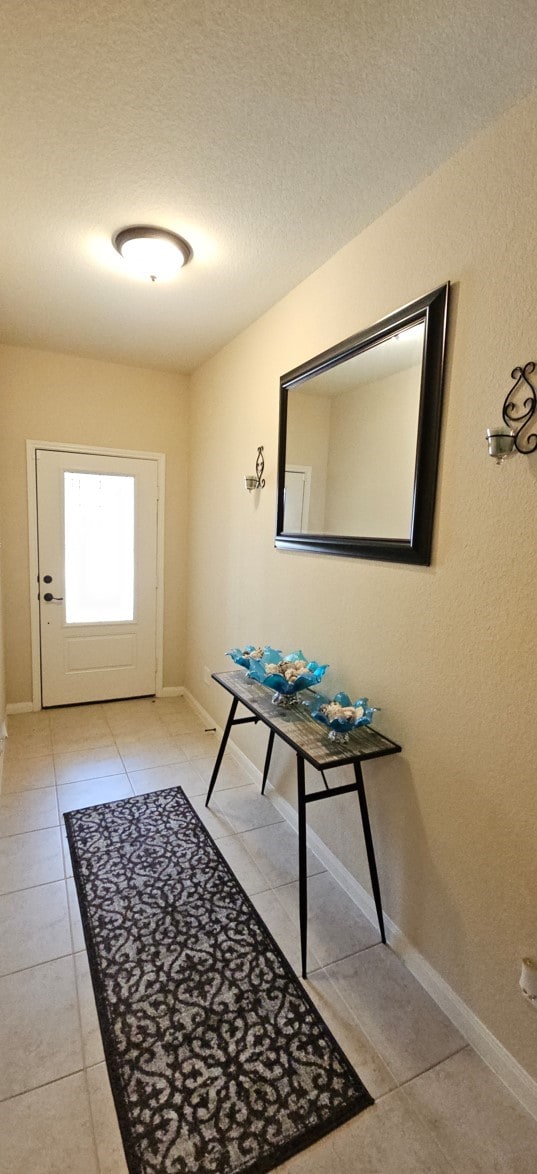 doorway featuring light tile patterned floors and a textured ceiling