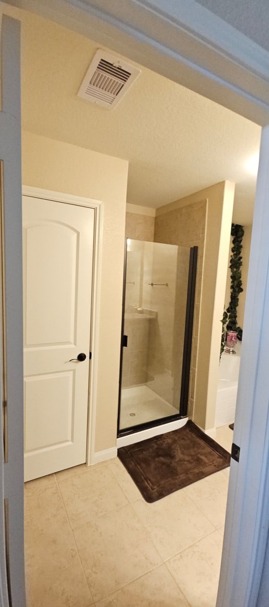 bathroom with tile patterned floors and a shower with shower door