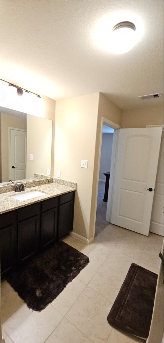 bathroom with tile patterned floors, vanity, and a textured ceiling