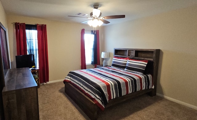 carpeted bedroom featuring multiple windows and ceiling fan