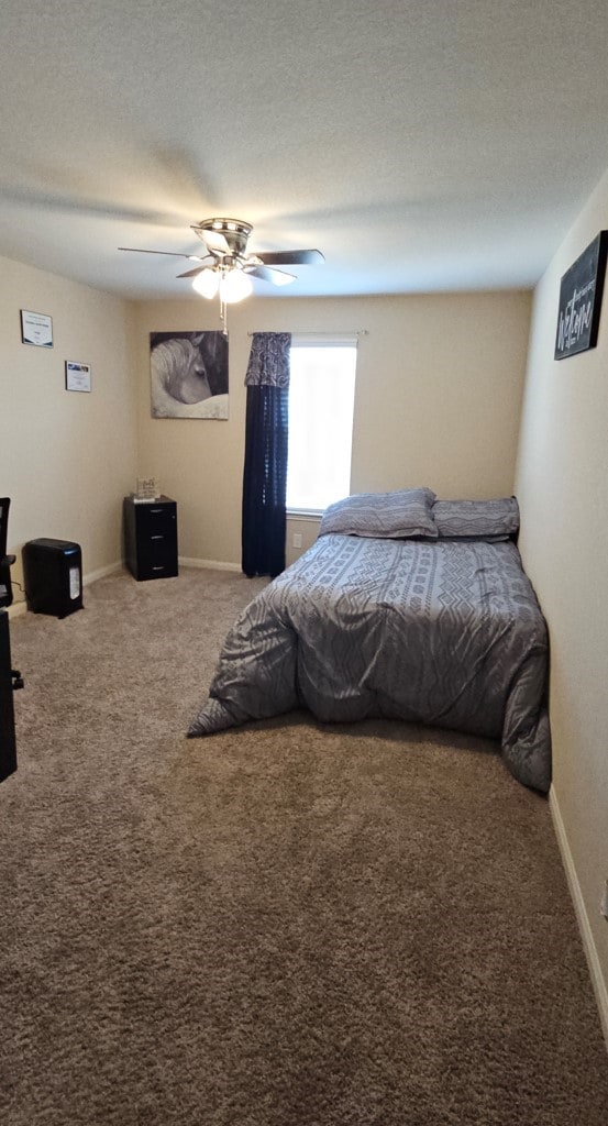 bedroom featuring ceiling fan, carpet floors, and a textured ceiling