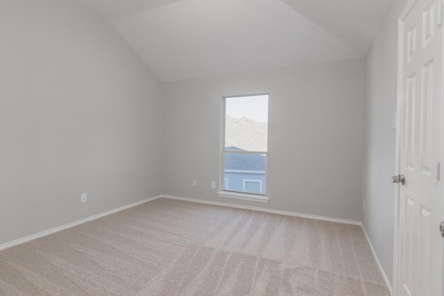 empty room featuring light colored carpet and vaulted ceiling