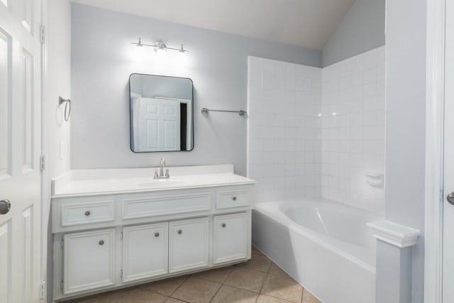 bathroom featuring vaulted ceiling, vanity, a bath, and tile patterned flooring