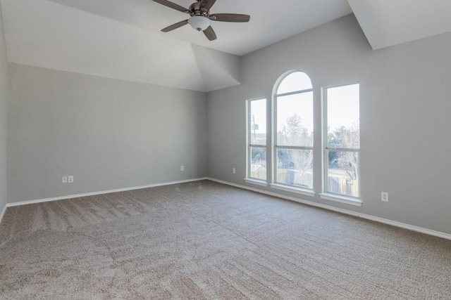 carpeted empty room with vaulted ceiling and ceiling fan