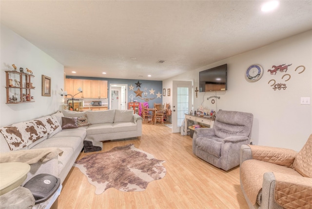 living room featuring a textured ceiling and light hardwood / wood-style flooring