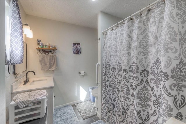 bathroom with vanity, toilet, and a textured ceiling