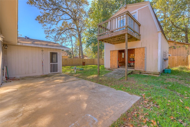 back of house featuring a yard, a storage unit, a patio area, and a wooden deck