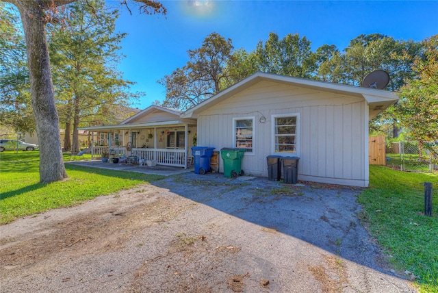 single story home with a porch and a front lawn