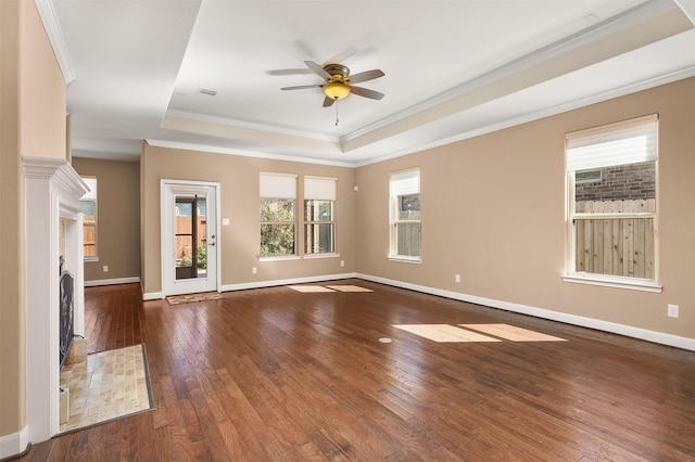 spare room featuring dark hardwood / wood-style floors, ceiling fan, crown molding, and a tray ceiling