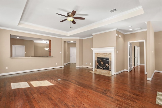 unfurnished living room featuring a raised ceiling, ceiling fan, and dark wood-type flooring