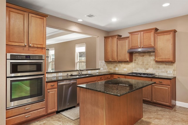 kitchen featuring sink, crown molding, dark stone counters, a kitchen island, and appliances with stainless steel finishes