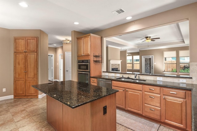 kitchen featuring ceiling fan, sink, stainless steel appliances, kitchen peninsula, and a kitchen island