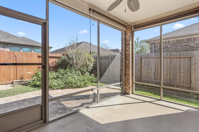 unfurnished sunroom featuring ceiling fan