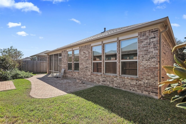 rear view of house featuring a patio area and a yard