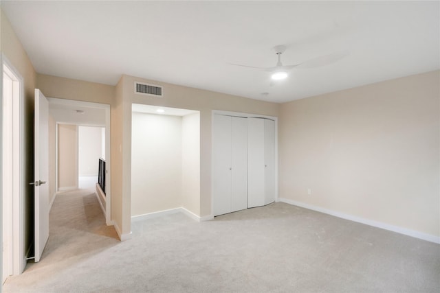 unfurnished bedroom with ceiling fan, a closet, and light colored carpet